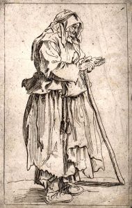An old woman dressed in rags holding a stick in her rig